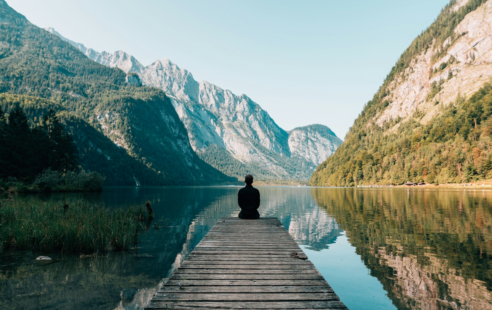 Osoba na molu uz planinsko jezero